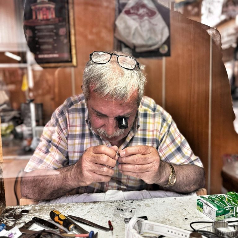 Eine Hand hält einen klassischen Kompass mit einer klaren Zifferntafel.