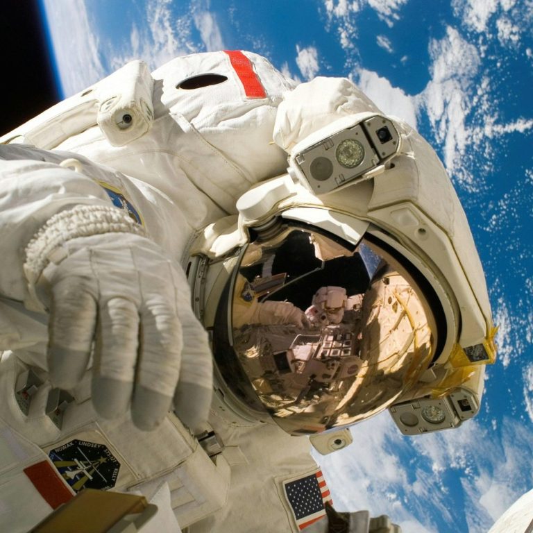 Ein Astronaut schwebt im Weltraum mit der Erde im Hintergrund.