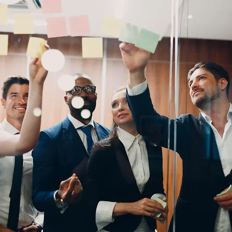 Gruppendiskussion mit Post-its an einem Fenster in einem modernen Büro.
