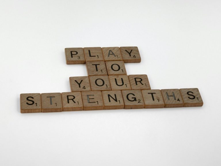 Buchstabenplättchen zeigen den Satz "PLAY TO YOUR STRENGTHS".